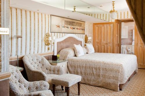 a bedroom with a bed and chairs in a room at Milestone Hotel Kensington in London