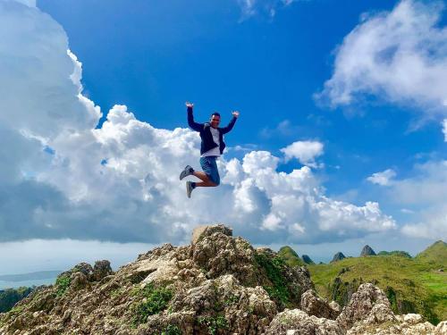 a person jumping in the air over some rocks at Jah’s Anemone Dive Guesthouse in Moalboal