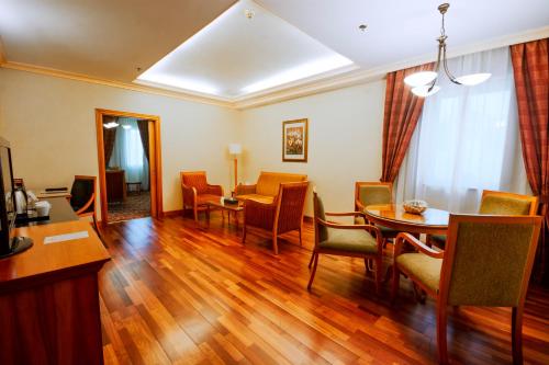 a living room with a dining room table and chairs at Avenue Hotel Dubai in Dubai