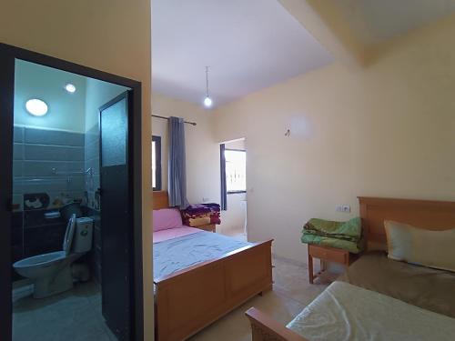 a bedroom with a bed and a bathroom with a shower at Hotel ASSAFIRE in Bou Mia