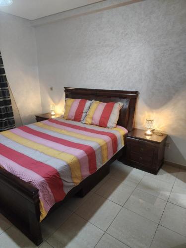 a bedroom with a bed with two night stands and two lamps at Anis Home in Agadir