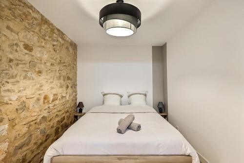 sypialnia z łóżkiem z kamienną ścianą w obiekcie Jacuzzi de charme pour 2 w mieście Nîmes