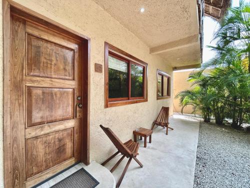 un portico con due sedie e una porta di Aldea Xaan Ha Tulum a Tulum