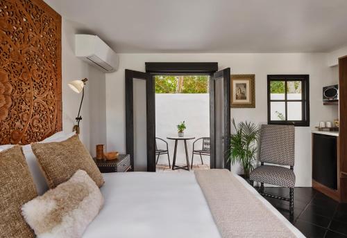 a bedroom with a bed and a table with chairs at Lucille Palm Springs in Palm Springs