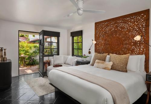 a bedroom with a large white bed and a chair at Lucille Palm Springs in Palm Springs