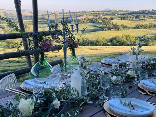 a table with plates and glasses and flowers on it at B&B Casa del Fonte in Corinaldo