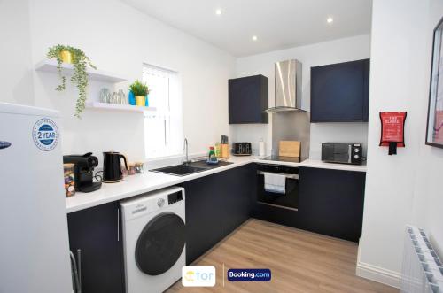 a kitchen with a washer and a sink and a dishwasher at Caxton House Newport by The One Retreats in Newport