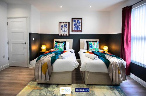 a bedroom with two twin beds in it at Caxton House Newport by The One Retreats in Newport