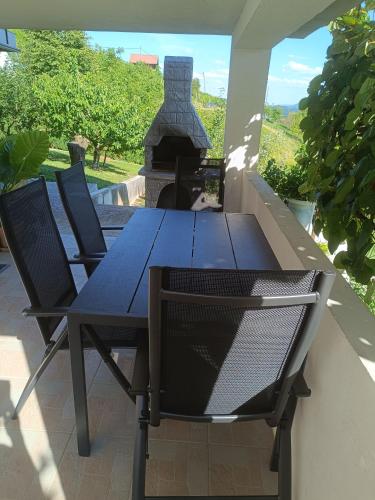 a table and chairs on a patio with a fireplace at Hiška na gorci in Podčetrtek