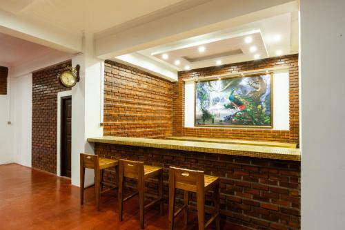 a bar with chairs and a brick wall at Trillium Boutique Express Hotel - Ward Place in Colombo