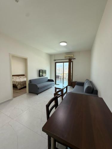 a living room with a table and a couch at Laforge Residence in Al Bāţiyah
