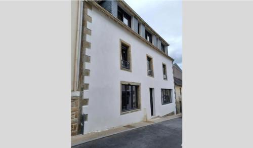 ein weißes Gebäude mit schwarzen Fenstern auf einer Straße in der Unterkunft AU PIED DE LA MER AU COEUR DE LA STATION bel appartement contemporain in Bénodet
