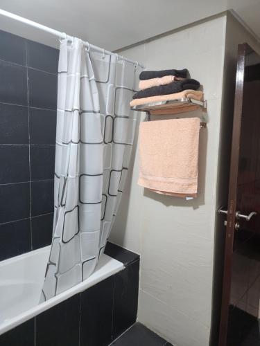 a bathroom with a shower curtain and some towels at Anis Home in Agadir