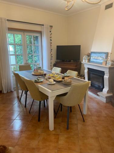 a dining room with a table with chairs and a television at Casa Magnolia B&B in Gafanha da Nazaré