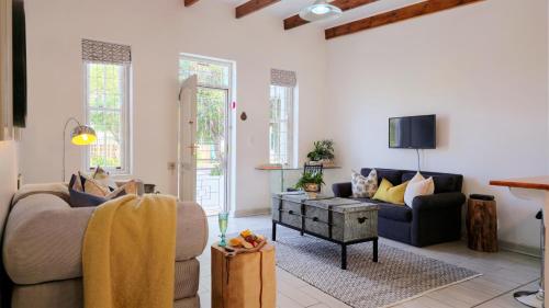 a living room with two couches and a tv at River Bend Guesthouses in Graaff-Reinet