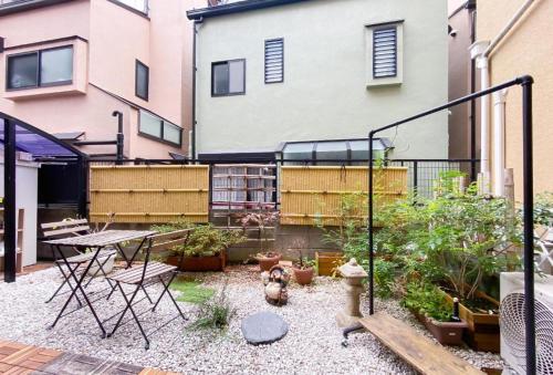 a garden with a fire hydrant and a table and chairs at We Guest House in Tokyo
