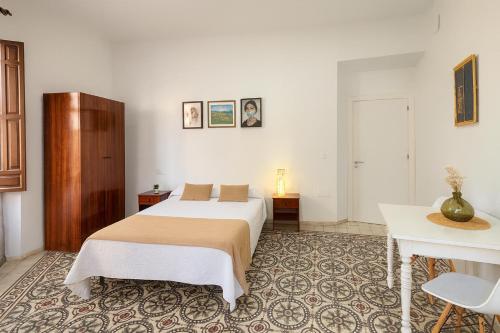 a bedroom with a bed and a table in a room at Casa Antares in Granada