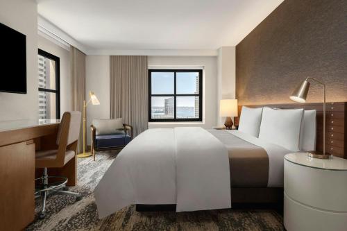a hotel room with a large bed and a desk at The Westin San Diego Gaslamp Quarter in San Diego