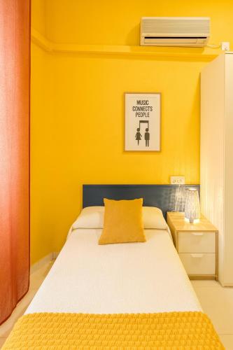 a bedroom with a bed with a yellow wall at Casa Antares in Granada