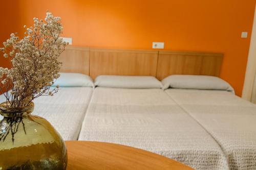 a bedroom with a bed and a vase with flowers on a table at Casa Antares in Granada