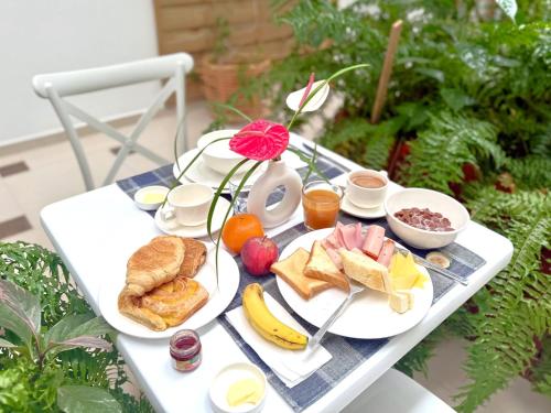a white table with breakfast foods on it at Residence Le Point Choisy in Pointe aux Cannoniers