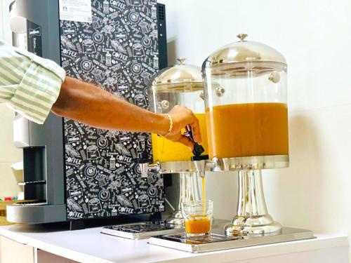 a person is making a drink in a blender at Residence Le Point Choisy in Pointe aux Cannoniers
