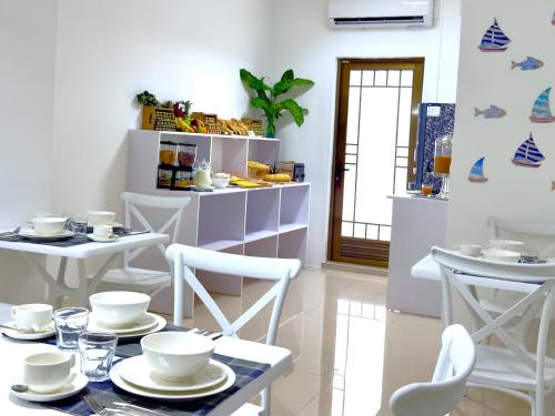 a dining room with white tables and white chairs at Residence Le Point Choisy in Pointe aux Cannoniers