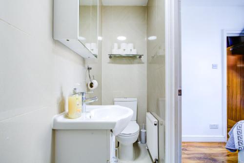 a white bathroom with a sink and a toilet at Abbey Hotel in London