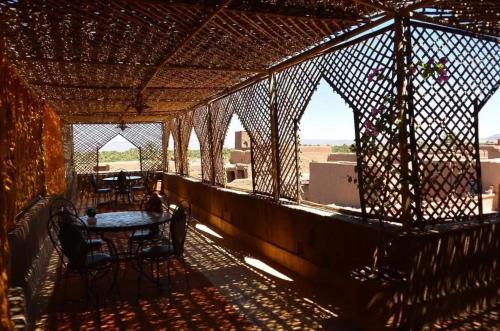 a patio with a table and chairs on a balcony at Kasbah Ziwana - Guesthouse in Zagora