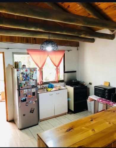 a kitchen with a refrigerator with magnets on it at Alma Verde in Tinguiririca
