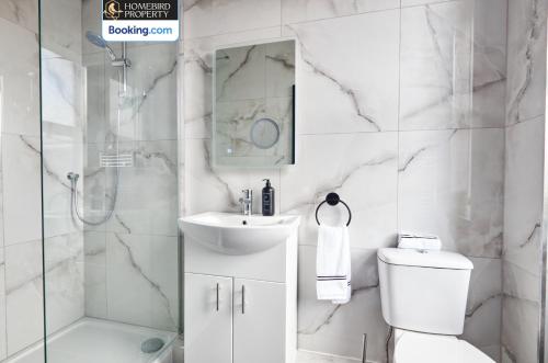 a bathroom with a toilet and a sink and a shower at Beautiful 3BDR House By Homebird Property Management Short Lets & Serviced Accommodation Leeds With Free Parking & Free WiFi in Leeds