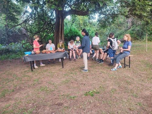 a group of people sitting on a bench under a tree at Sorabora like view camps in Mahiyangana