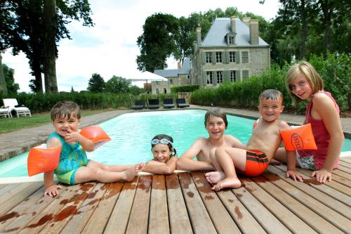 - un groupe d'enfants assis à côté d'une piscine dans l'établissement Château de Planchevienne, à Magny-Cours