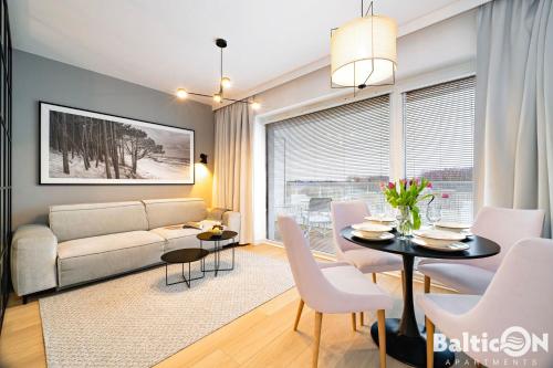 a living room with a couch and a table at Apartamenty BalticON Polanki Aqua in Kołobrzeg