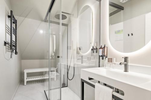 Un baño blanco con dos lavabos y una ducha. en Casa do Patio by Shiadu, en Lisboa