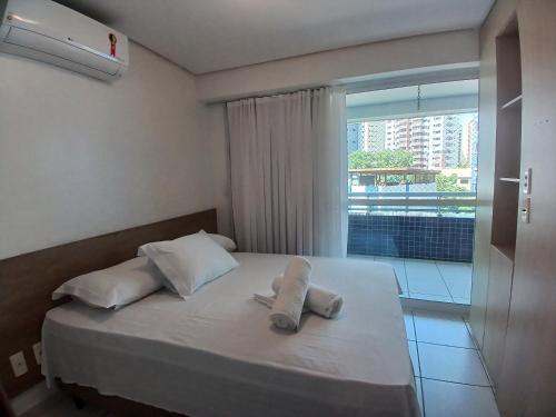 a bedroom with a bed with two towels on it at Beach Class Fortaleza in Fortaleza