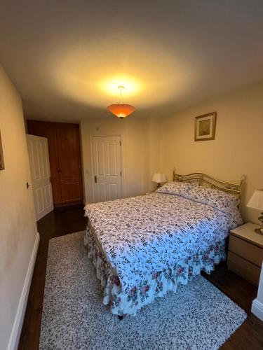 a bedroom with a bed with a blue comforter at Lough Rinn - Mac Raghnaill Court in Rivers Town