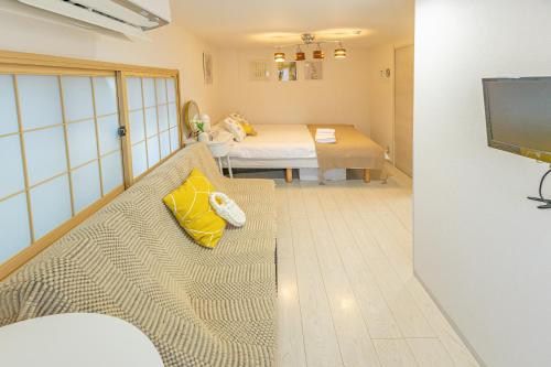 a small room with a couch and a bed at KOSUMOSU Ikebukuro Shinjuku Private House in Tokyo