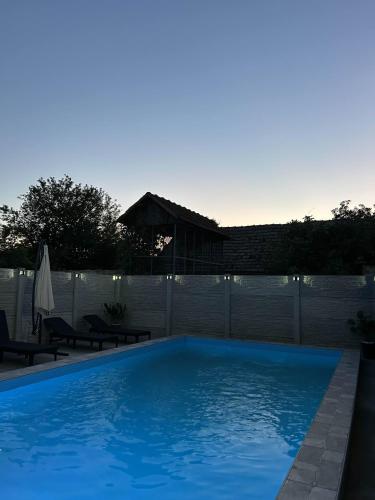 a large blue swimming pool in a backyard at Apartman Crvenka bazen in Crvenka