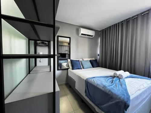 a small bedroom with a bed and a mirror at Get One - Bessa in Tambaú