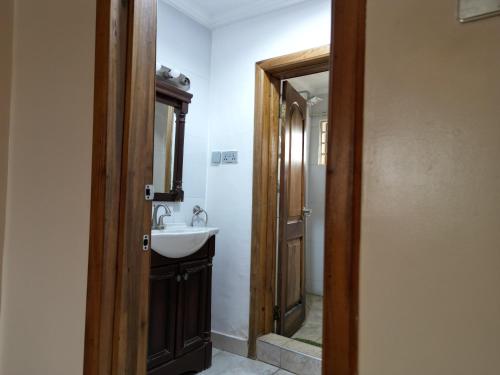 un baño con lavabo y espejo en Kadny Villa, en Accra