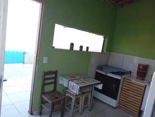a kitchen with a stove and a table and chairs at Casa Pôr do Sol in São Thomé das Letras