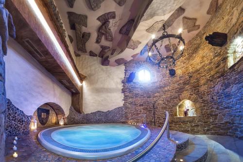 a large bathroom with a large tub in a stone wall at Hotel Podlesí in Podlesí