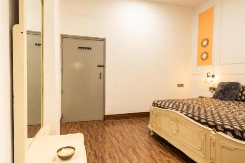 a bedroom with a bed and a door to a hallway at AnandMai Ghar - A Homestay in Gwalior in Gwalior