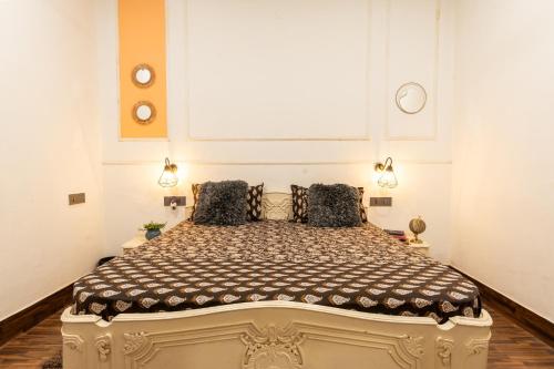 a bedroom with a large bed with two pillows at AnandMai Ghar - A Homestay in Gwalior in Gwalior