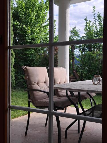 a porch with a chair and a table and a window at Ferienoase Berg & See in Feldkirchen in Kärnten