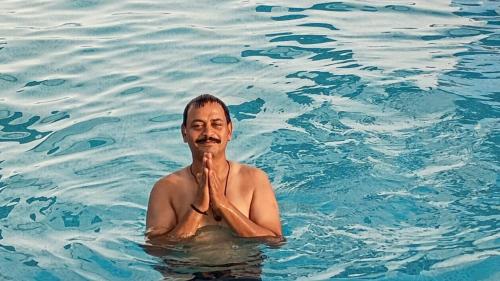 an older man swimming in the water at Kasera Paradise in Būndi