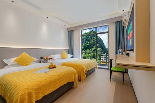 ein Hotelzimmer mit zwei Betten und einem Fenster in der Unterkunft Garden Villa Resort Yangshuo in Yangshuo