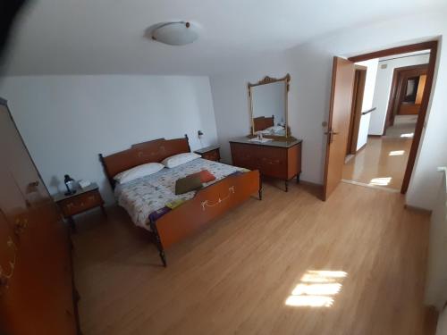 a bedroom with a bed and a dresser and a mirror at Al Viandante Casa Rosa in Sitran