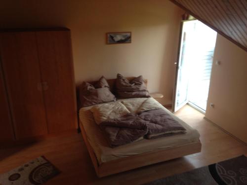 a bed with pillows on it in a room at Daja Ház in Hévíz